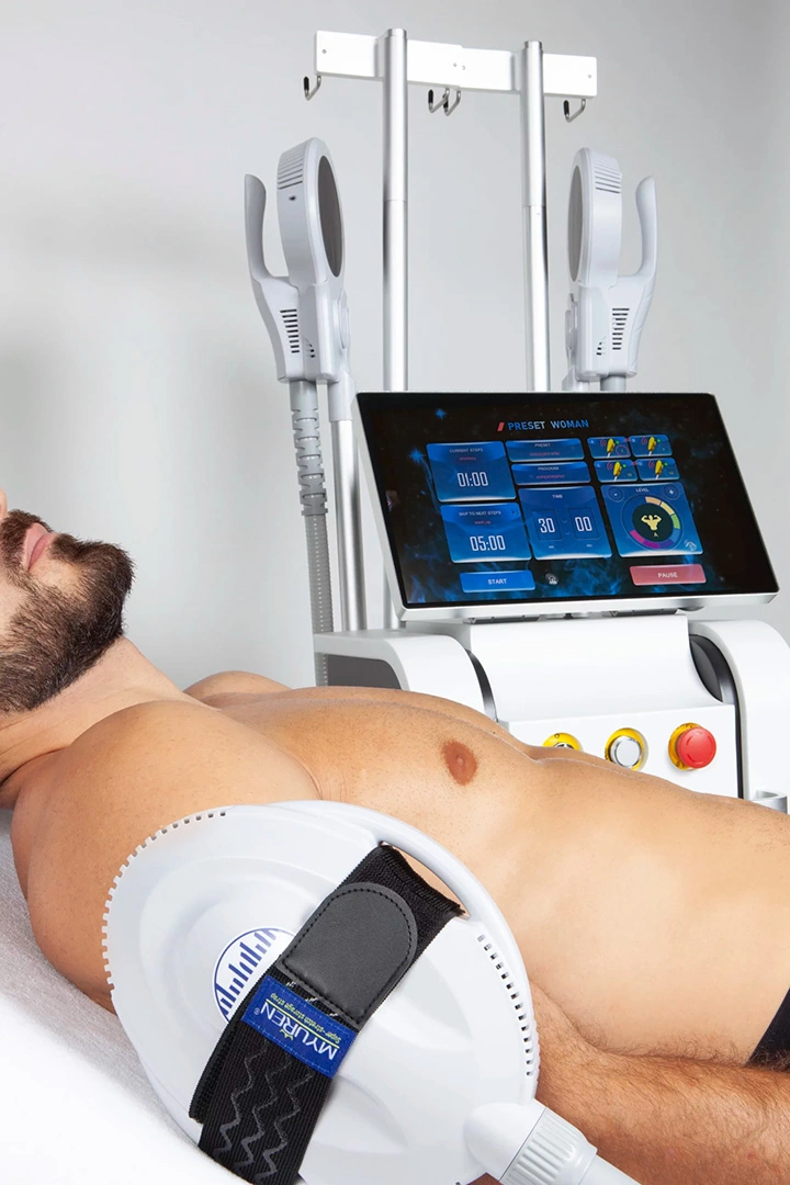 Homme pendant une séance EMS sur le bras, à côté de l'écran de contrôle de la machine Esthe-SHAPE